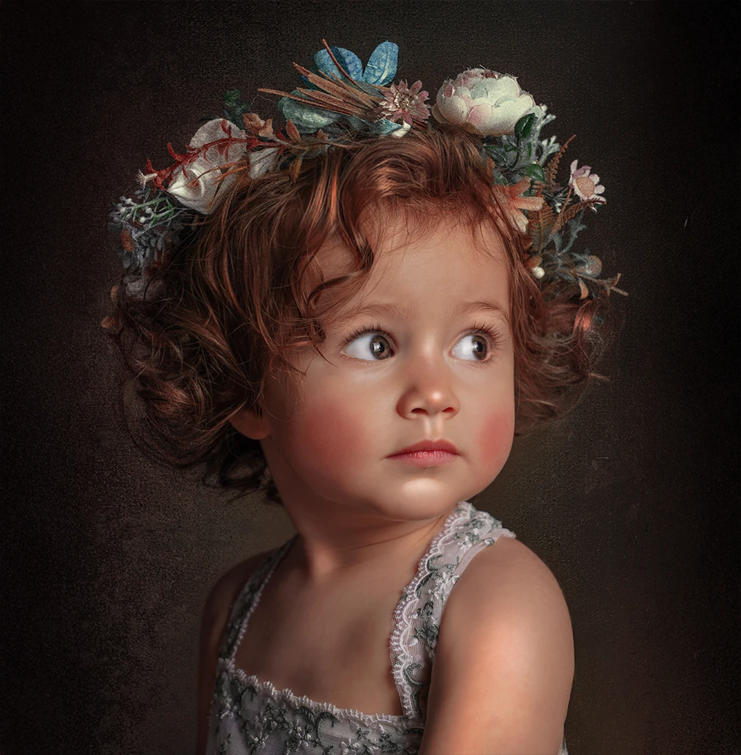 Toddler girl with curly hair wearing a floral crown and lace dress, artistic fine art children’s portrait at Parapluie Studio Lebanon.